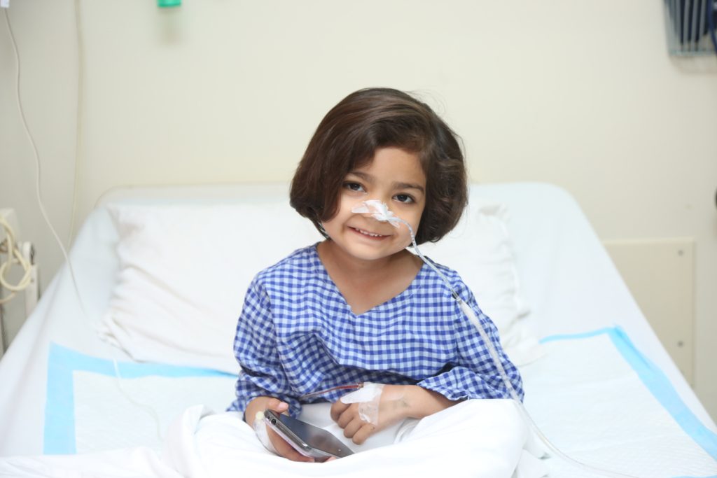Child receiving care in hospital bed